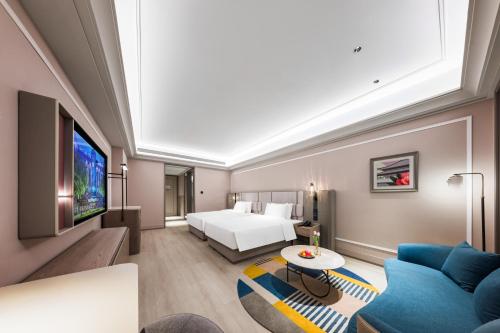 a hotel room with a bed and a couch at Mercure Xi'an New Software City in Xi'an