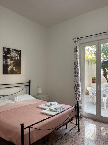 a bedroom with a bed and a sliding glass door at Residence Prato in Trapani