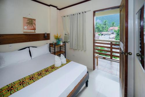 a bedroom with two beds and a balcony at Silverise Guest House in El Nido