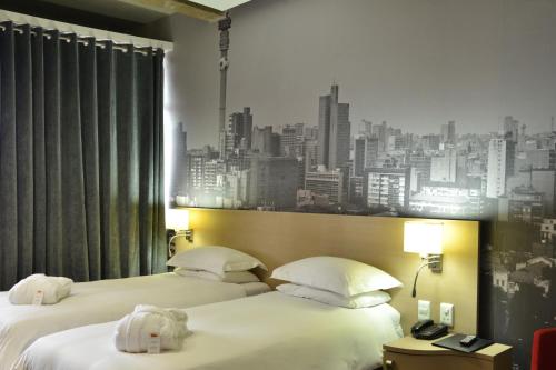 two beds in a hotel room with a city skyline at Reef Hotel in Johannesburg