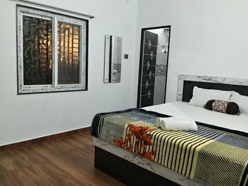 a bedroom with a bed and a window at VIDYA Homestay in Hampi