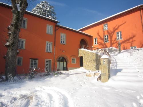 an orange building with snow in front of it at Agriturismo Villa Le Vigne in Montevarchi