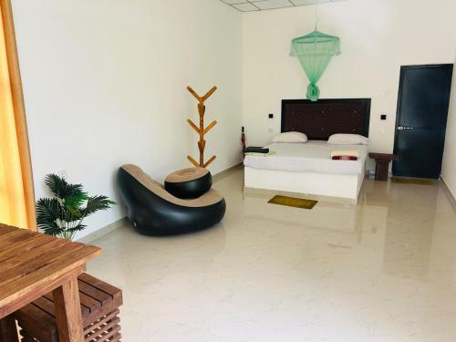 a bedroom with a bed and a couch and a chair at Hotel Mandara Udawalawe in Udawalawe