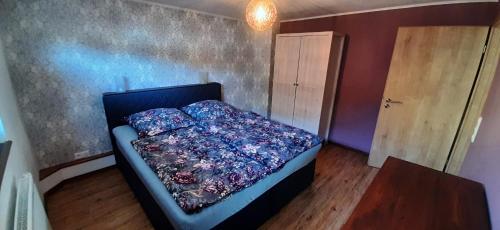 a bedroom with a bed with a blue comforter at Herzstück Ferienwohnung Waxweiler in Waxweiler