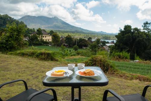 a picnic table with two plates of food on it at Royal Indah Glamping Kintamani in Kintamani