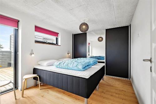 a bedroom with a large bed with blue sheets at 0431-Romo-Vestergade-333 in Høm