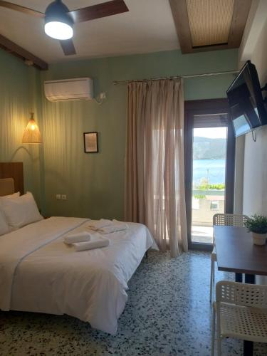a bedroom with a bed and a table and a window at Pteleo Apartments in Pteleos