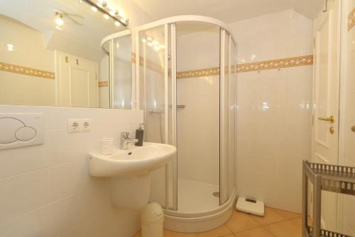 a white bathroom with a shower and a sink at Sommer Munkmarsch in Munkmarsch