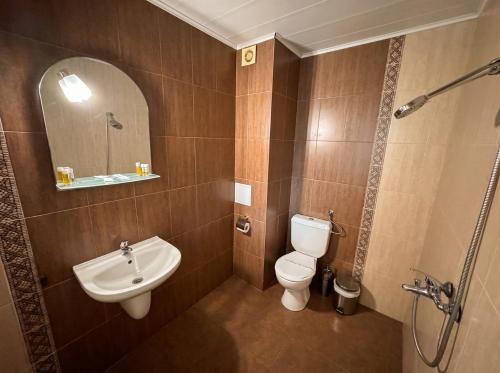 a bathroom with a toilet and a sink and a mirror at Семеен Хотел Примо Family Hotel Primo in Primorsko