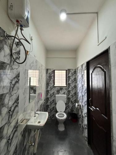 a bathroom with a toilet and a sink at Rajratna lodge in Lohogaon