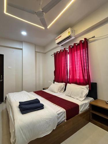 a bedroom with a bed with a red curtain at Rajratna lodge in Lohogaon
