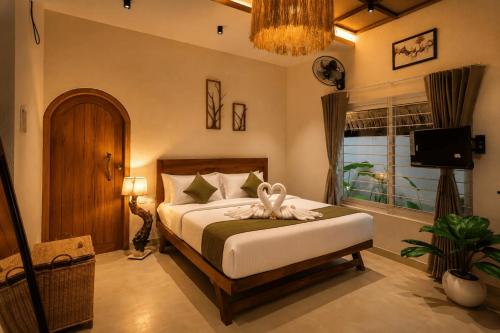 a bedroom with a bed and a window at Ayana Lake Resorts in Kovillūr