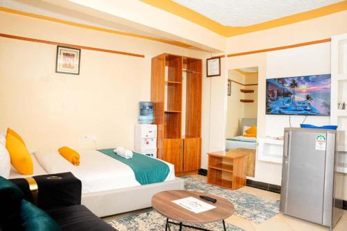 a living room with a bed and a couch at Toquee Hotel Bookings - Nairobi in Nairobi