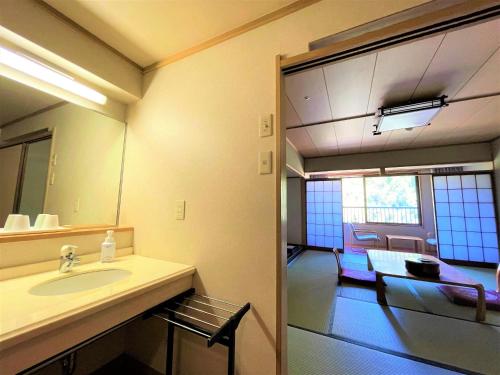 a bathroom with a sink and a mirror at Miyajima Morinoyado in Miyajima