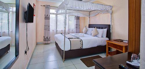 a bedroom with a bed with a canopy at Toquee Hotel Bookings - Nairobi in Nairobi