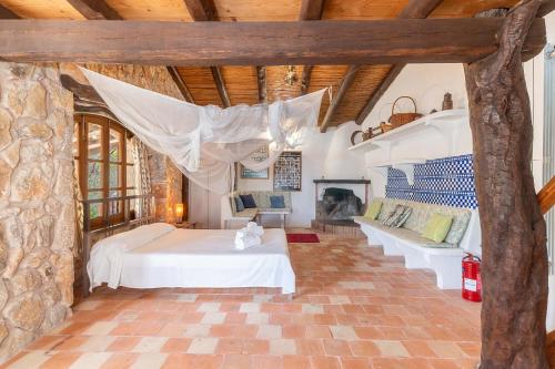 a bedroom with a bed and a stone wall at Can Xilla by Sealand Villas in Alcudia