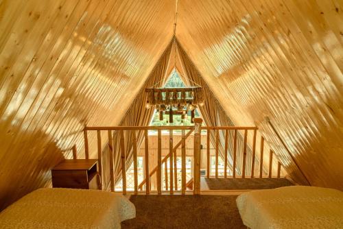 an attic room with two beds and a window at A-frame Sky in Karakol
