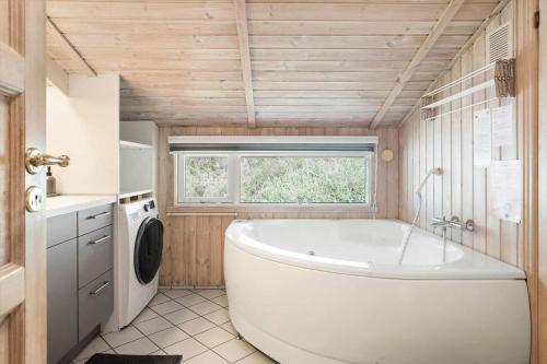 a large white tub in a bathroom with a window at 0011-Romo-Trinnesvej-9 in Høm