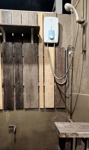 a shower in a bathroom with a bench and a hose at Nhiên Café & Homestay in Xuân Trường