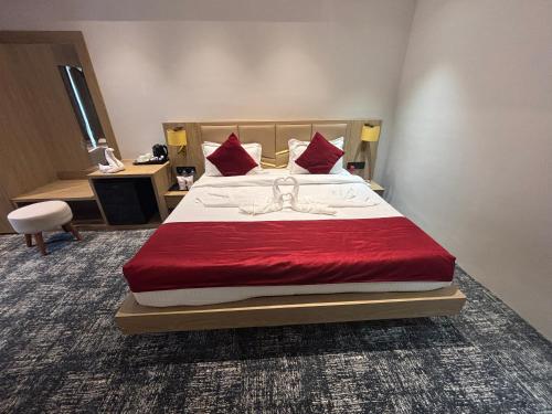 a bedroom with a large bed with red pillows at The Chinmaye Grand in Bhāgalpur