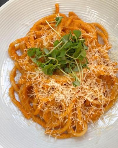 a plate of pasta with cheese and greens on it at Bhimtaal cottages in Bhīm Tāl