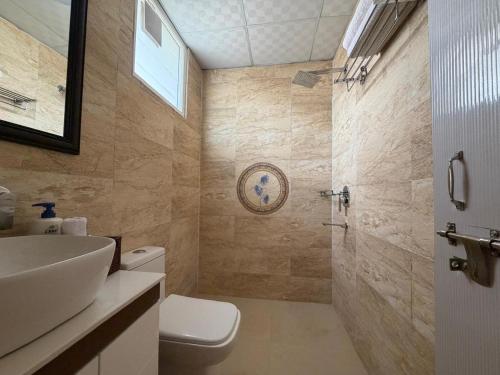 a bathroom with a toilet and a sink and a shower at The Annexe in Greater Noida