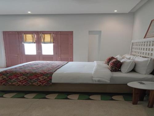 a bedroom with a large bed and a table at DanCenter Parijat Villas & Suites Udaipur in Udaipur
