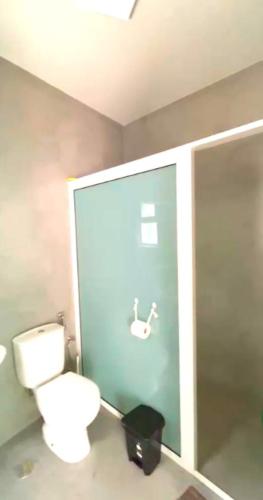 a bathroom with a toilet and a glass door with a sink at Refúgio NO Stress in Paul