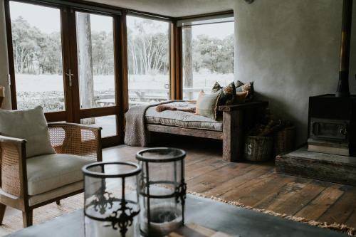 a living room with a bed and a fireplace at Kanuka Terrace - Luxury Strawbale House in Kaikoura