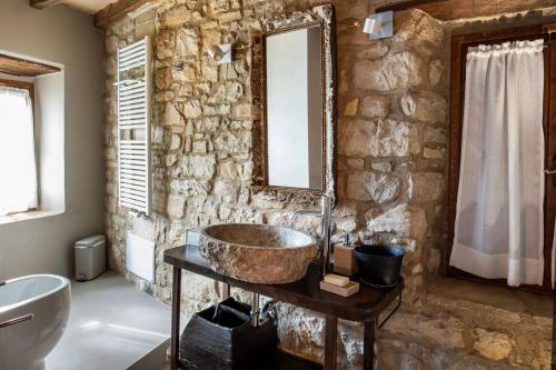 a stone bathroom with a sink and a mirror at Borgo Vercallo in Case la Selva