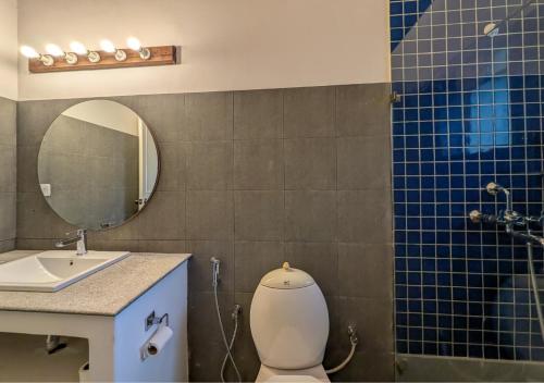 a bathroom with a toilet and a sink and a mirror at Beach villa Candolim in Candolim