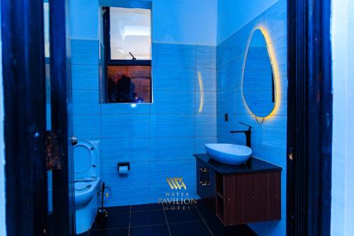 a blue bathroom with a sink and a toilet at WATER PavilioN HOTEL in Keroka