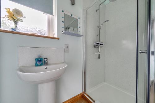 a bathroom with a sink and a shower at Ashclose Lodge Annexe in Sherborne