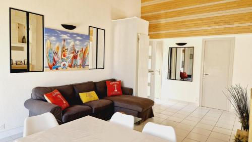 a living room with a couch and a table at Le Rivage, maison proche mer avec Spa in Les Sables-d'Olonne