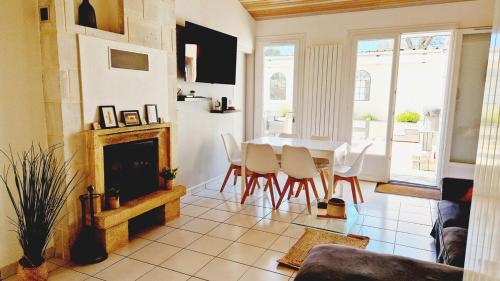 a living room with a fireplace and a table and chairs at Le Rivage, maison proche mer avec Spa in Les Sables-d'Olonne