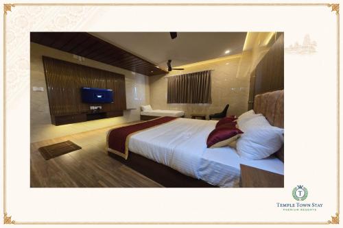 a hotel room with a bed and a flat screen tv at Temple Town Stay in Kanchipuram