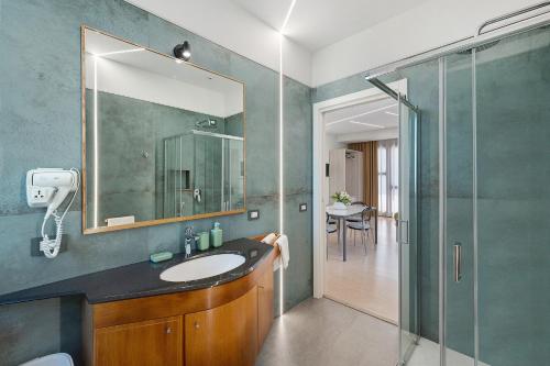 ein Badezimmer mit Waschbecken und Glasdusche in der Unterkunft Sunshine Apartment in Pimonte