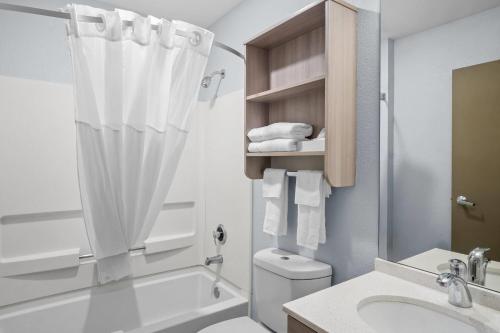a bathroom with a tub and a toilet and a sink at Microtel Inn Georgetown - Lexington North in Georgetown