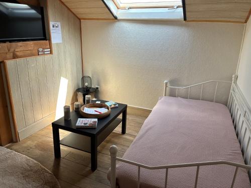 a small room with a bed and a table with a table at Les gîtes du Chemin Le Compostelle in Paray-le-Monial