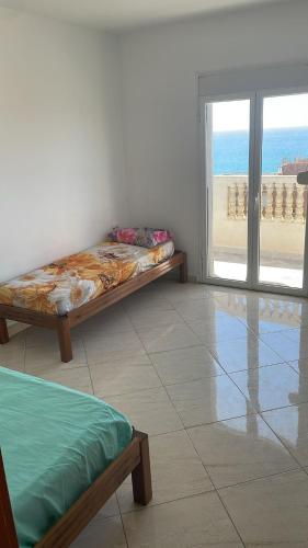 a bedroom with a bed and a view of the beach at Appartement proche mer 