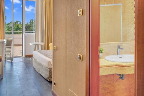 a room with a bathroom with a sink and a bed at Hotel Roma Aurelia Antica in Rome