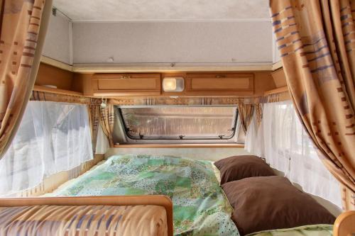 a bed in the back of an rv at Caravane au jardin in Brix