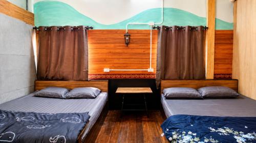 ein Schlafzimmer mit zwei Betten und einem Fenster in der Unterkunft โรงแรมคุ้มเดช - KoomDech Hotel in Sattahip
