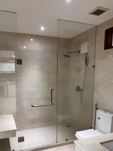 a bathroom with a glass shower with a toilet at Q Kata Residence in Kata Beach