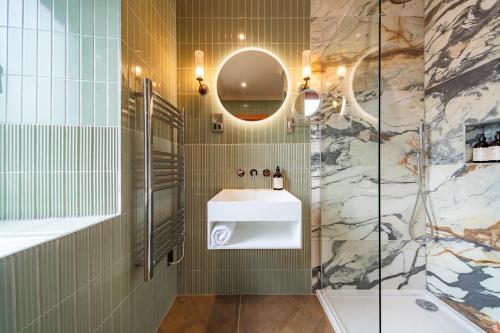a bathroom with a sink and a shower at The Mill House in Stewarton