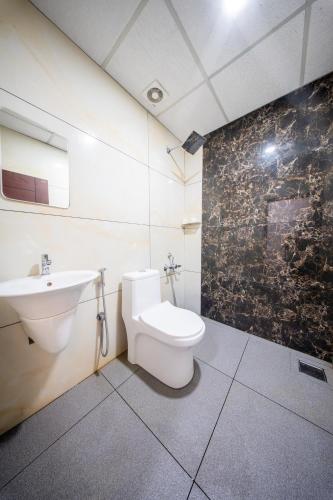 a bathroom with a toilet and a sink at BREEZA GRANd in Kazhakuttam