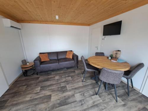 a living room with a table and a couch at Cube 97 I 4 persoons chalet met hottub in Zennewijnen