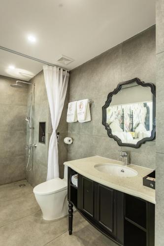 a bathroom with a sink and a toilet and a mirror at PG indochine Mộc Châu in Sơn La