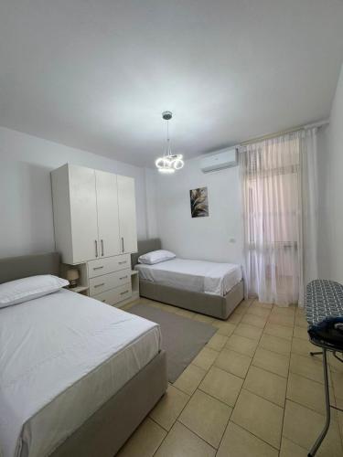 a bedroom with two beds and a chair in it at Lushnja Central Elegance in Lushnjë