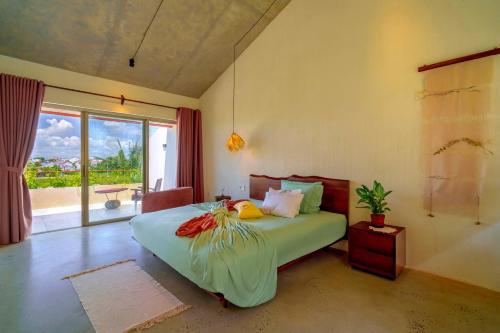 a bedroom with a bed and a large window at Camfusion Hoi An in Hoi An